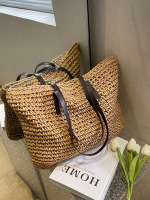 Natural woven straw shoulder bag with dark brown leather straps, shown in khaki.