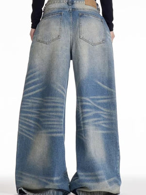 Men's wide leg blue washed denim jeans with a baggy fit and distressed details.