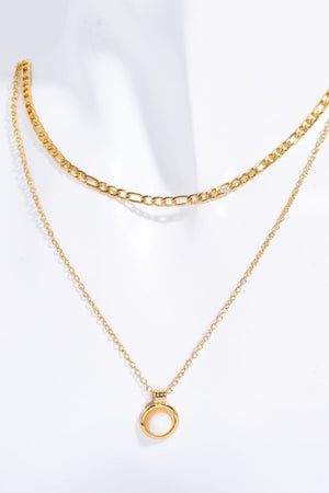 Gold layered necklace with a white aventurine orb pendant.