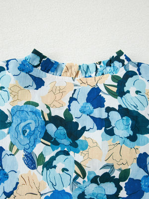 Cotton blouse with vibrant blue floral print and ruffled mock neckline.