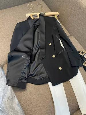 Black double-breasted tailored blazer with satin lapels and gold buttons, shown open to reveal satin lining.