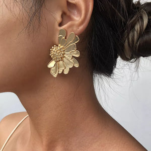 Textured gold flower stud earrings with detailed petals and a beaded center.