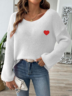 White boatneck knit sweater with embroidered red heart detail.