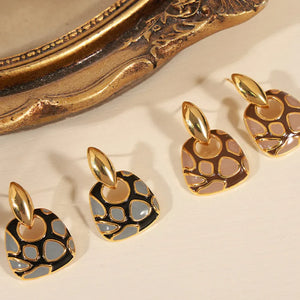 Geometric enamel drop earrings in black and brown with gold accents.