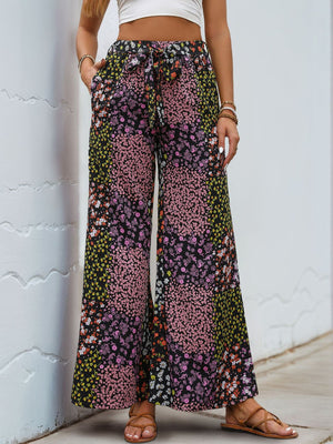 Black floral panel palazzo trousers with a tie waist and wide legs.
