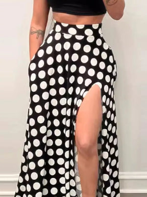 Black and white polka dot maxi skirt with a high slit and pockets.