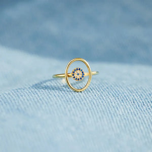 Gold oval ring with blue and clear evil eye detail