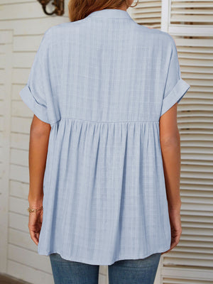 Light blue linen blend blouse with gathered yoke, short sleeves, and subtle plaid texture.