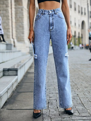 Ripped high-waisted light wash denim jeans with button closure.