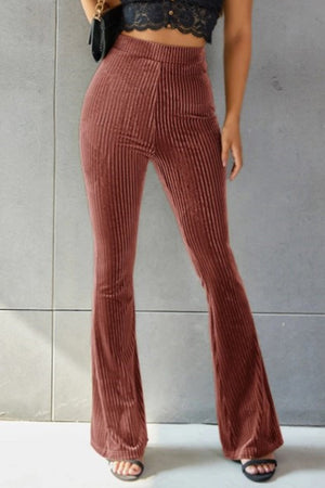 Ribbed velvet palazzo trousers in rust, with a high waist and flared leg.
