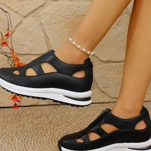 Chic black cutout wedge sneakers with zipper detail and chunky sole.