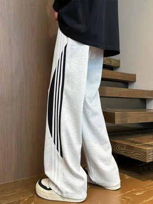 Men's light gray wide leg casual trousers with black and white side stripe detail.