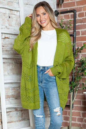 Open-knit slouchy cardigan in matcha green acrylic with openwork chevron details and relaxed fit.