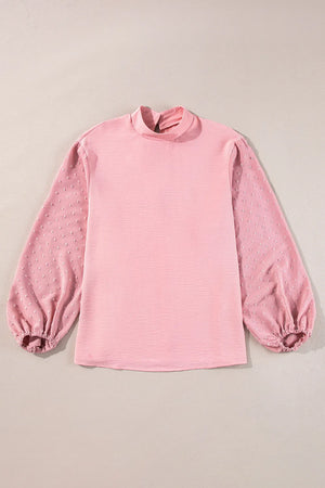 Blush pink blouson top with textured fabric and Swiss dot puff sleeves.