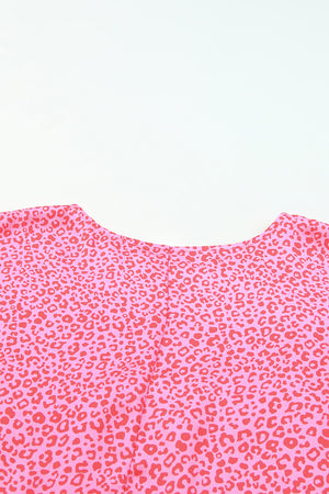 Pink leopard print blouse with smocked sleeves and crew neck detail.