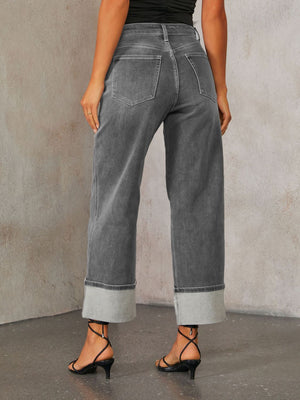 Dark wash denim jeans with wide legs and cuffed hems.