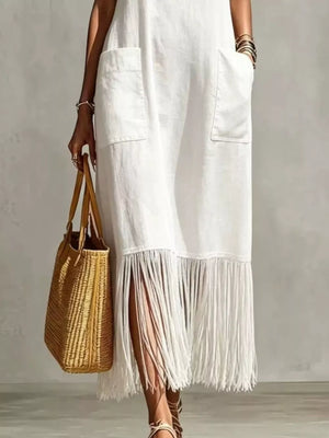White maxi dress with fringe hem and side slits, featuring pockets.