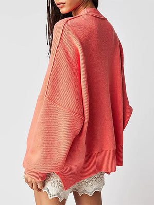 Oversized ribbed knit sweater in coral with drop shoulders and a mock neck.