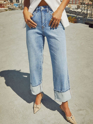 Light wash denim jeans with wide legs and cuffed hems.
