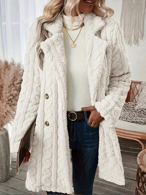 White faux shearling double-breasted coat with cable knit texture and button closure.