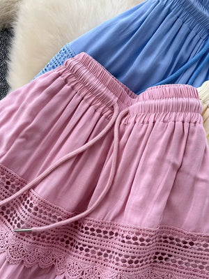 Pink tiered skirt with drawstring and lace trim detail.