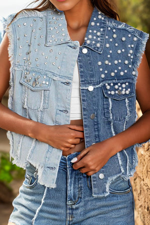 Two-tone denim vest with pearl and rhinestone embellishments, distressed details, and frayed hem.