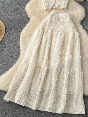 White textured two-piece set with ruffled details and tiered skirt.