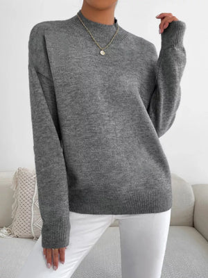 Gray mock neck knit sweater with dropped shoulders, ribbed cuffs and hem.