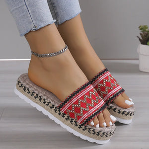Red embroidered espadrille platform slides with woven jute sole and zigzag trim.