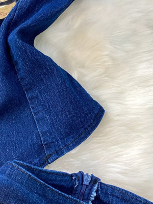 Dark blue cotton denim vest detail with zipper closure on flare jeans.
