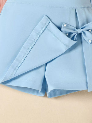 Sky blue skort with pearl-embellished bow detail and neat stitching.