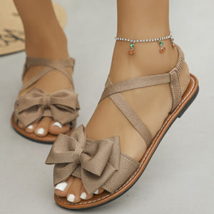 Charming crisscross bow sandals in khaki with ankle strap detail.