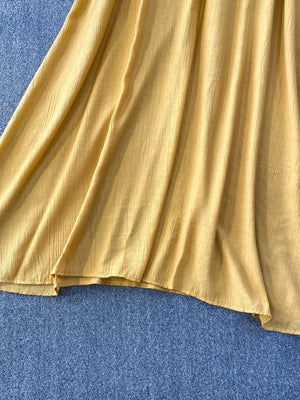 Yellow textured fabric detail of a flowy two-piece set
