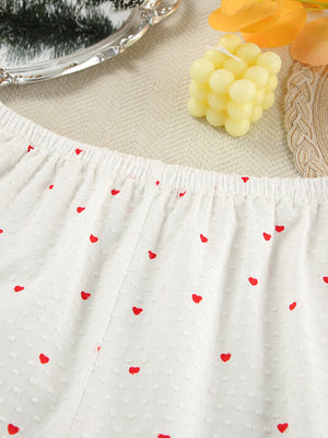 White cotton pajama shorts with red heart print and textured fabric.