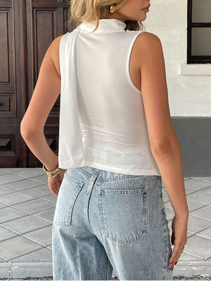 White draped cowl neck cami top with a flowing detail on the side.
