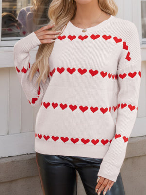 Ivory knit sweater with red heart stripes, crew neck, long sleeves.
