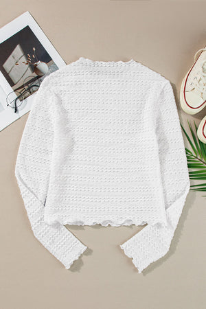 White textured long sleeve top with ruffle trim and scalloped hem