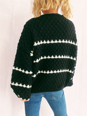 Black textured knit jumper with white chevron stripes, crew neck, long sleeves.