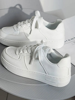 White minimalist platform sneakers with lace-up closure and perforated toe box.