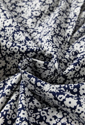 Bloomchic blouse with navy and white floral print and notched sleeves.