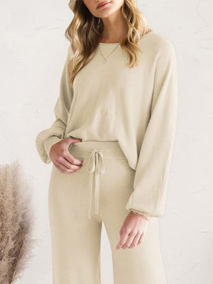 Ivory knit loungewear set with wide-leg pants and a crewneck sweater.