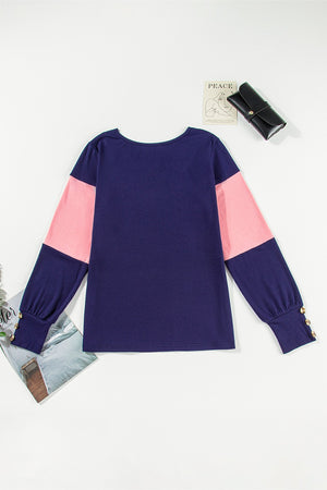 Navy and blush pink contrast panel sweater with button cuff detail.