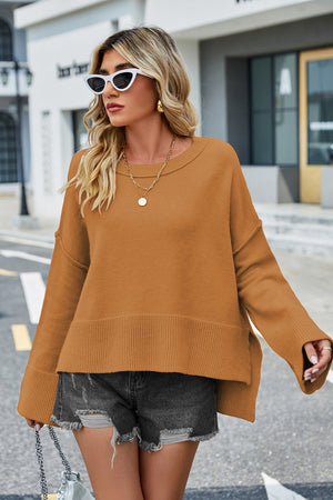 Caramel acrylic knit sweater with flared sleeves and slit hem detail.