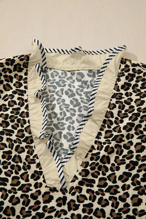 Leopard print mini dress with ruffle trim and striped neckline detail.