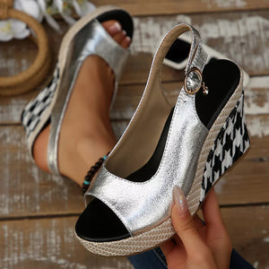 Sleek open-toe wedge sandals in silver with decorative buckle and houndstooth wedge.