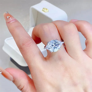 Sterling silver ring with a large trillion-flanked moissanite center stone.