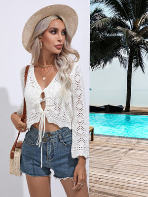 White lace-inset tie-front cardigan with open knit details and a keyhole neckline.