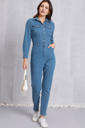 Denim utility jumpsuit in medium wash with defined waist, long sleeves, and button front.