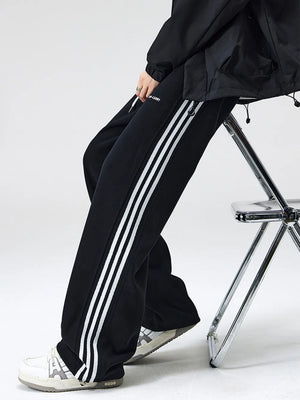 Black cotton sweatpants with white side stripes and drawstring waist.