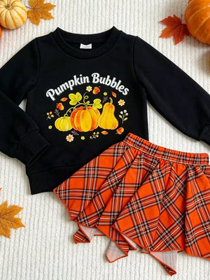 Black long sleeve top with Pumpkin Bubbles graphic and orange plaid skirt.